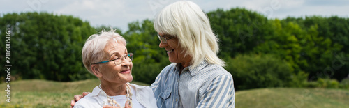 Фотография Elderly couple enjoying a heartfelt moment on a sunny grassy hill