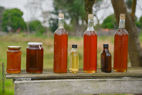 Obraz na płótnie botellas de miel casera sobre la madera rústica