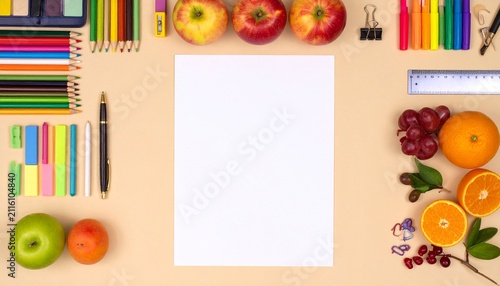 Workspace with stationery and fruits.