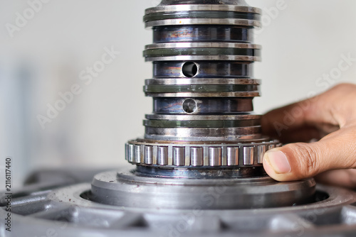 Mechanic installing bearing on transmission shaft.