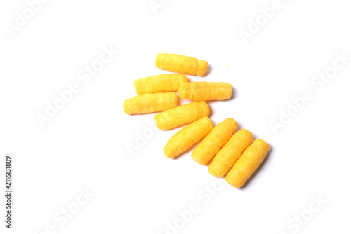 Cuadro en lienzo A small pile of crunchy, bright yellow corn puff snacks arranged diagonally on a plain white background