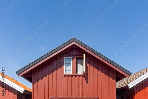 Photography Red wooden house gable with open window in Fjällbacka
