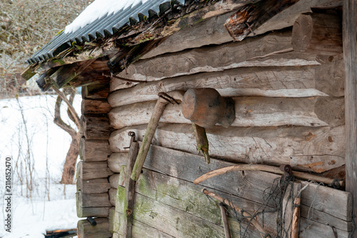 Obraz na plátně Wooden cabin structure with tools and snow in a rural area during winter