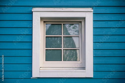 8K photo of a window on a old cottage in white and blue. A classic Swedish style of of home. Close up shot.