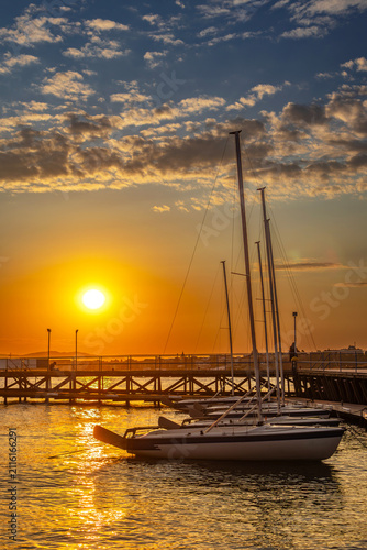 Sailing yachts moored at wooden pier at sunset in sea resort Ravda, Burgas, Bulgaria