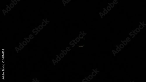 video of a bright full moon in the night sky gradually disappearing behind moving clouds. Dramatic clouds pass across the moon, creating a mysterious and atmospheric nocturnal landscape