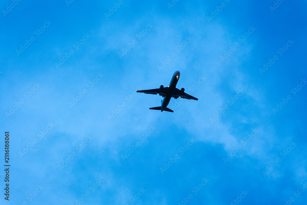 Fototapeta premium Airplane flying above blue sky with clouds during daytime