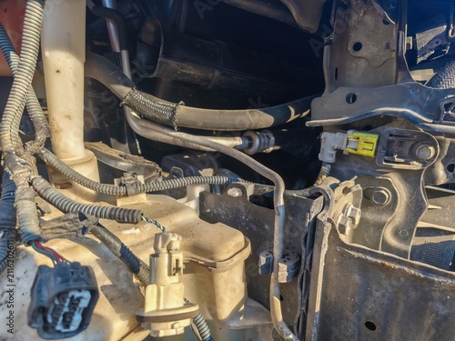 Detailed view of exposed engine bay wiring hoses and mechanical components inside a dismantled vehicle during automotive repair and maintenance work