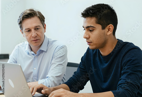 Two men collaborating on a ...