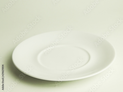Photography Empty round white ceramic plate saucer isolated on plain light background