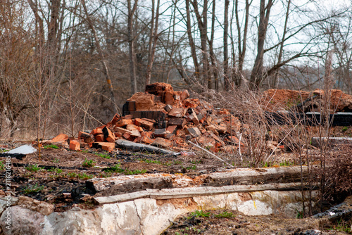 Foto Abandoned site with a pile of bricks and scattered debris in a wooded area