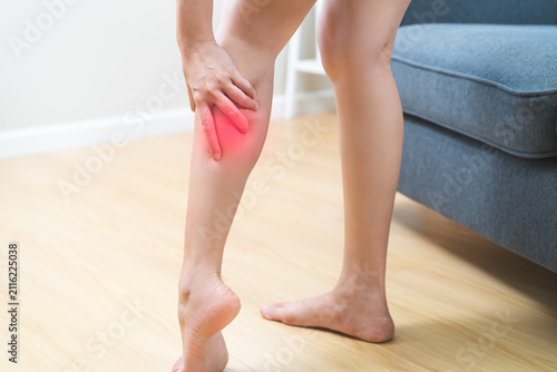 Cuadro en lienzo Muscle pain or leg pain, suffer asian young woman, girl hand massaging brawn leg calf muscle cramps or spasm, trauma from inflammation of tendon at calves while standing at home
