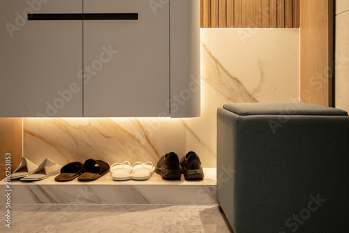 Foto Modern entryway interior with illuminated built-in shoe rack cabinet and slippers