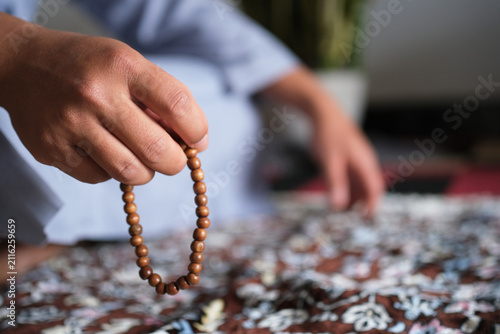 Bild auf Leinwand Close-up of hands reciting dhikr using prayer beads