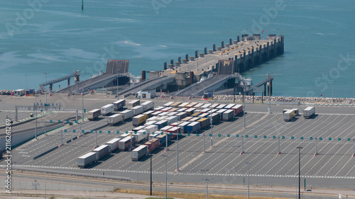 Calais, France - 09 July 2026: Aerial view of the Port of Calais ferry entrance with numerous semi-trucks parked in the terminal waiting area near the English Channel.