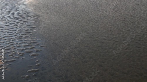 Beautiful abstract sand art peaceful background from the changing of the tide of the ocean at the beach