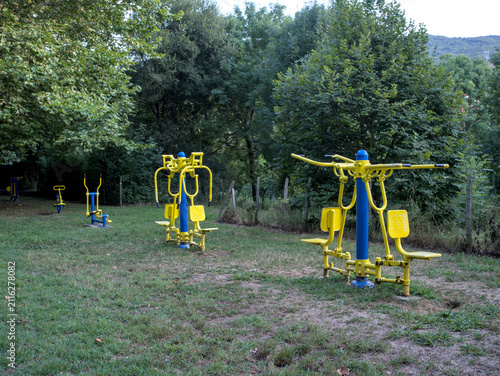 Bild auf Leinwand Gimnasio al aire libre en un parque entre la naturaleza donde se pueden observar las máquinas de hacer ejercicio entre los árboles