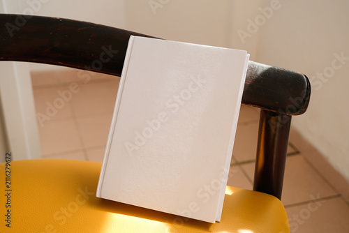 empty book mockup on soft chair indoors