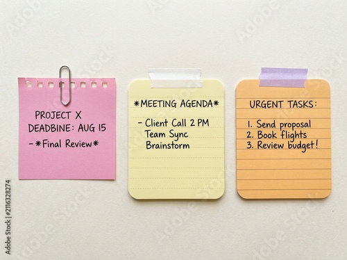Colorful handwritten sticky notes with to do list, reminder and study tasks attached with paper clip and tape, simple planning and organization concept on neutral background
