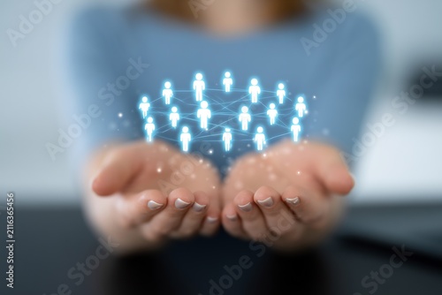 Hands holding glowing network of people icons against a blurred background, symbolizing connection and community.