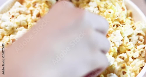 handling and eating popcorn before watching a movie with a large group. Movie buffs