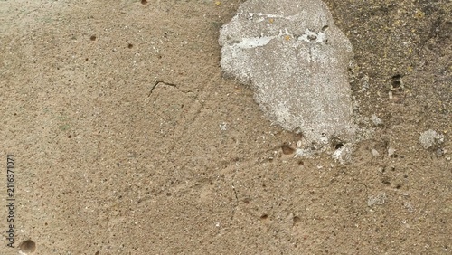 Chipped Plaster Wall Beige textured exterior coating showing a chunk missing revealing underlayer for home repair services renovation guides and textural overlays