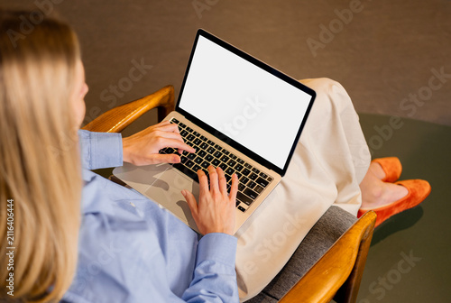 Business woman working on laptop with white screen mockup