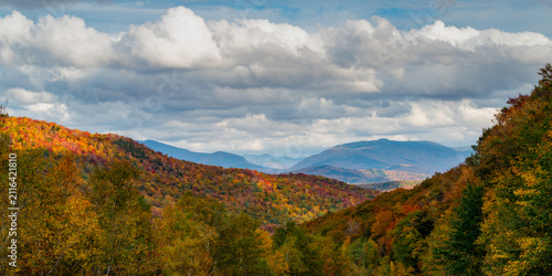 Autumn mountain landscape with vibrant fall foliage and cloudy sky