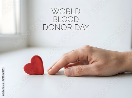 World blood donor day concept with a human hand reaching out to a red heart shape icon