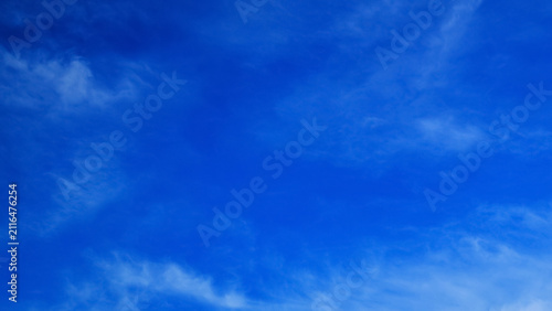 clear bright blue sky with light feathery clouds on a sunny day