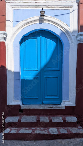 Quadro su tela Porte en bois bleue voûtée dans une façade traditionnelle grecque, île de Symi