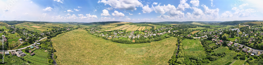 Fototapeta premium Aerial landscape view of green and yellow cultivated agricultural fields with growing crops on bright summer day