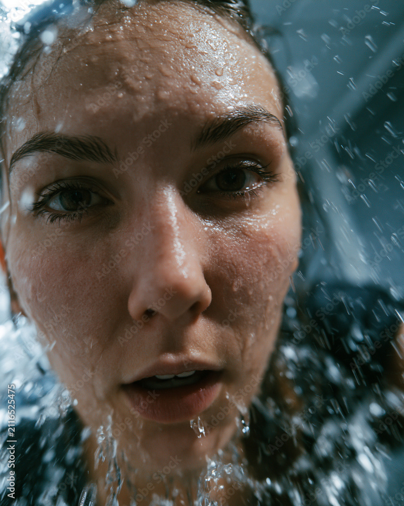 Fototapeta premium Surprised Woman Portrait with Dripping Water – Intense Emotion and Candid Beauty Shot in Studio Photography