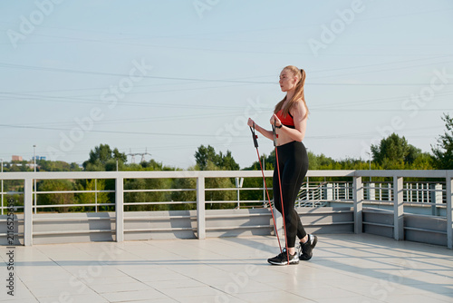 Obraz na plátně The athlete shakes the triceps with an expander
