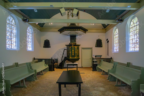 17 May 2015: View of the interior of a historic chapel featuring an ornate green and gold pulpit with a sounding board, rows of wooden pews, and arched windows under a vaulted ceiling.