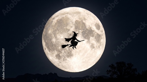 A dark silhouette of a witch riding a broomstick flies across a massive, detailed full moon in a night sky.