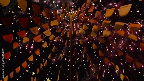 First rockets launching, fireworks bursting, canopy framing upward, flags glowing, for festival