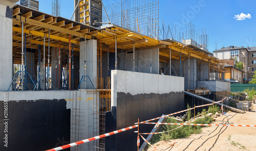 Fotografía An ongoing construction site displaying concrete structures, scaffolding, and clear blue sky