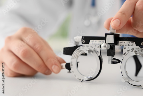 Female oculist adjusting tr...