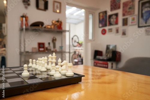 Chess game on wooden table in bright modern living room