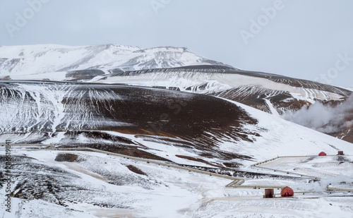 Krafla power geothermal plant snow and ice covering volcanic slopes with steam vents. Iceland sustainable energy