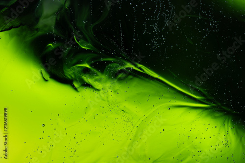 Green liquid flowing creating abstract swirl patterns