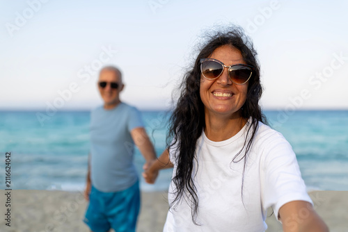 Woman smiling holding hand with man on beach
