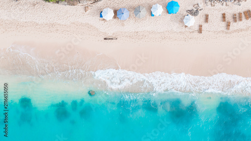 Beautiful Bali beach with white sand and umbrellas, clean azure water of the sea. 