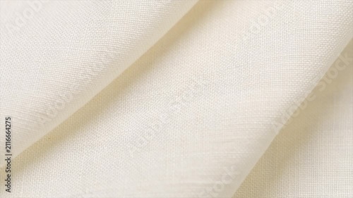 Cotton with linen fabric folds, white homespun vintage fabric, natural eco folded linen background. Bio textile material backdrop, canvas top view, close up, rotating. 