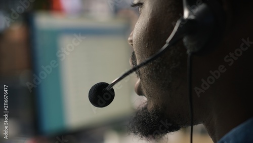 Foto Close-up of a call center agent speaking through an audio headset while handling complaints and supporting dissatisfied clients with customer service issues in an office workplace