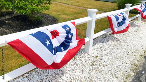 Foto USA bunting flags attached to a white fence rails swaying on a windy day