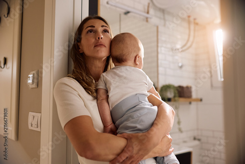 Cuadro en lienzo Young mother going through postpartum depression while holding her baby at home