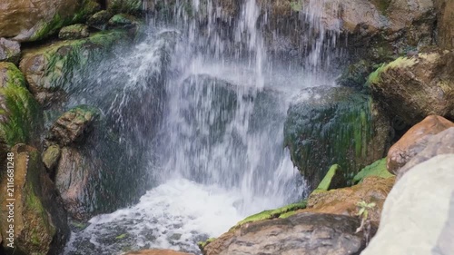 Powerful water flowing over mossy rocks at waterfall