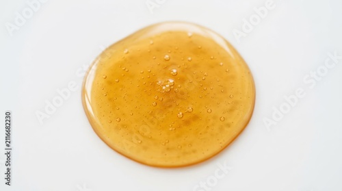 Golden Honey Droplet on White Background Macro Shot.